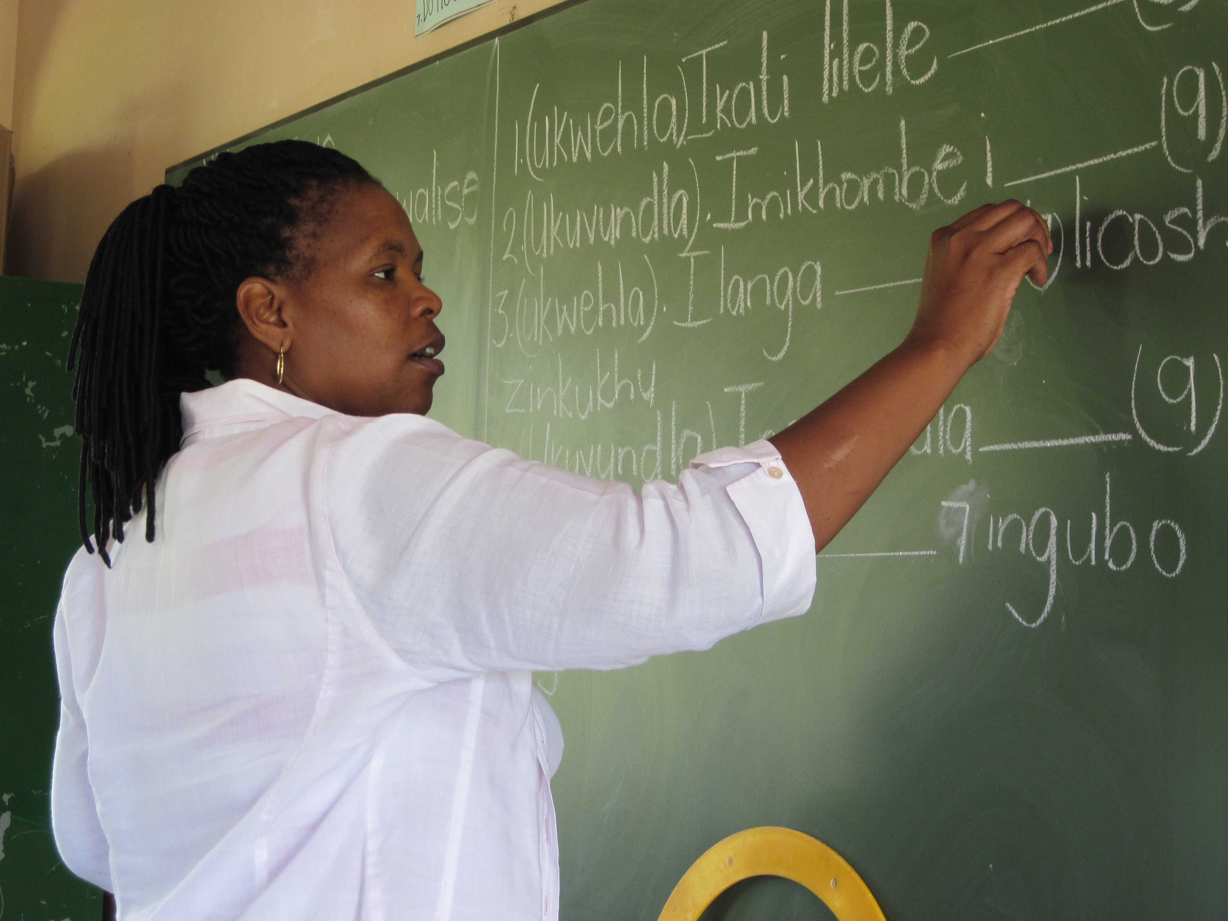 Child’s View – Ms. Zondi, a teacher, writes on the chalkboard during a seventh grade Zulu language class