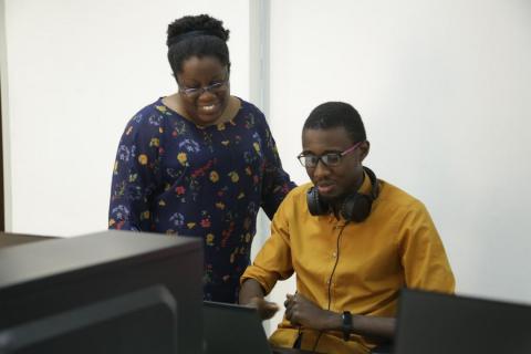 Judith Okonkwo, founder of Imisi 3D, working with a member of her team on a VR for education project.